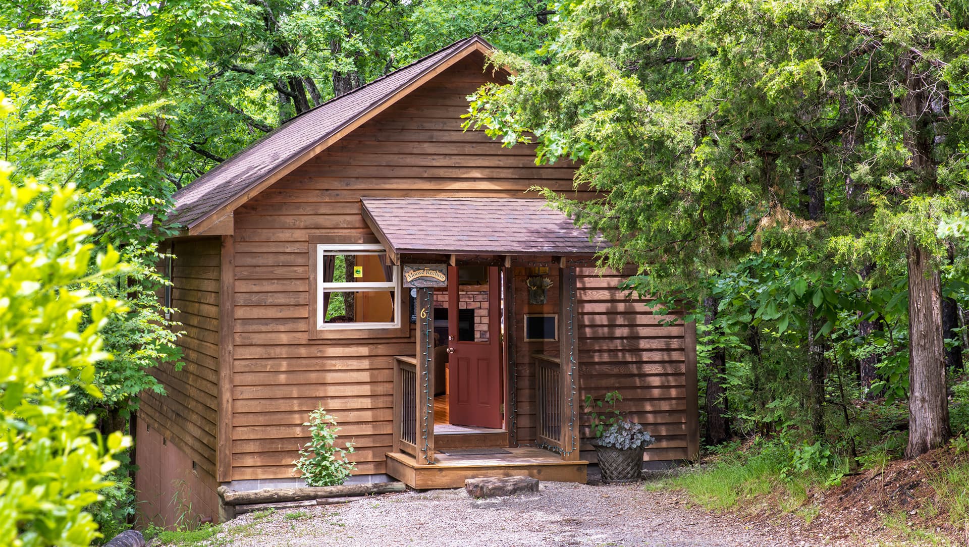 A rustic wooden cabin surrounded by trees.