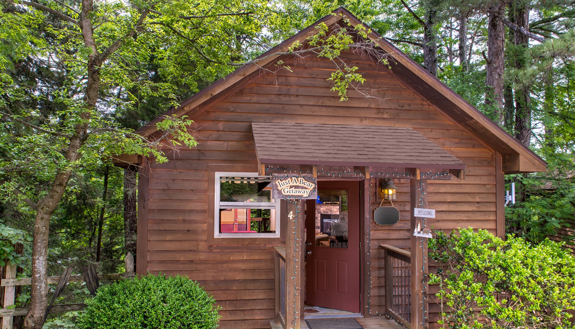 A cozy wooden cottage surrounded by trees and greenery.